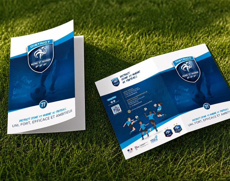 Brochure District 77 Football Chemise et brochure du District Seine-et-Marne de Football posées sur une pelouse